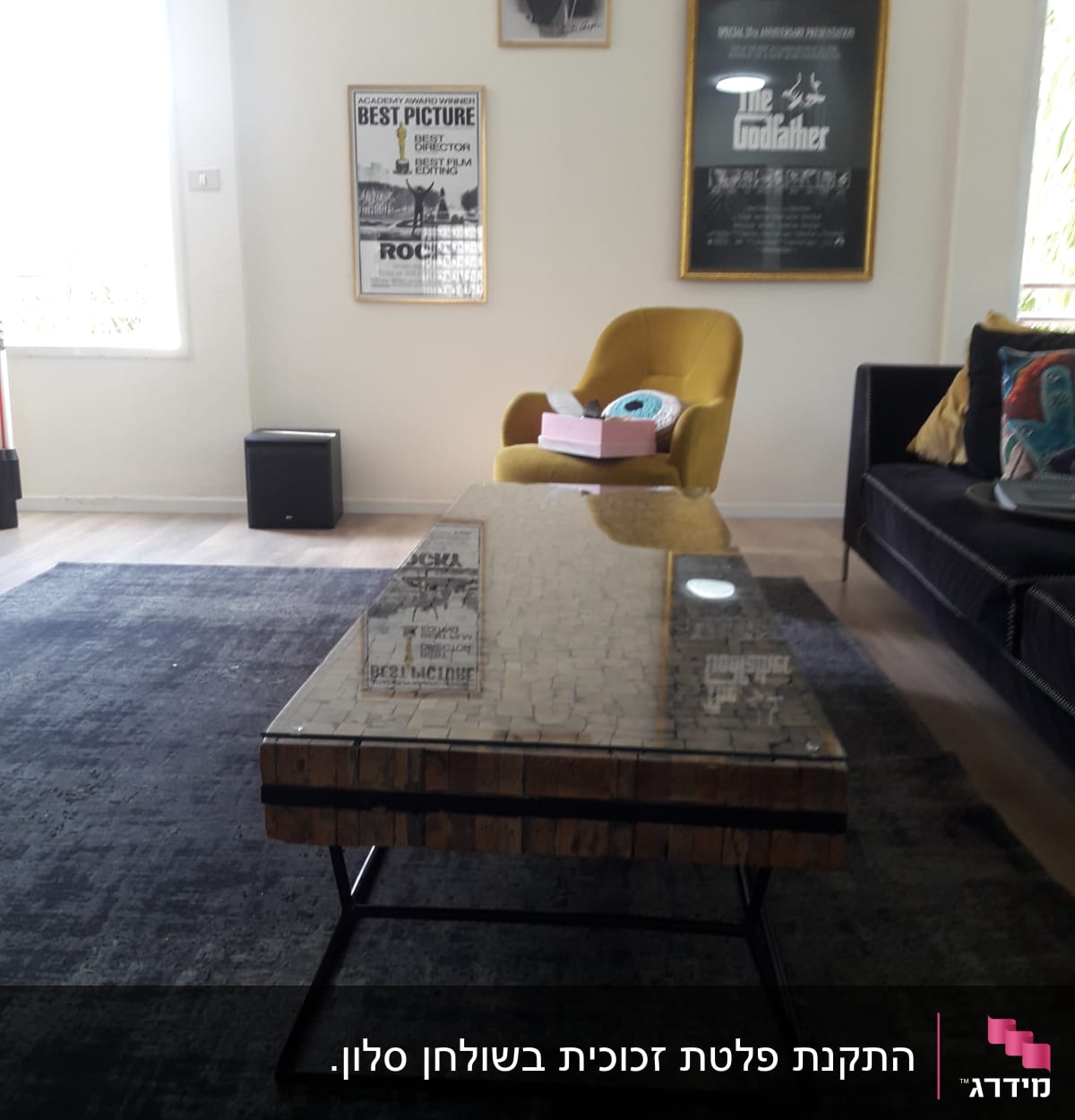 שולחן זכוכית עם השתקפות פוסטרים על הקיר